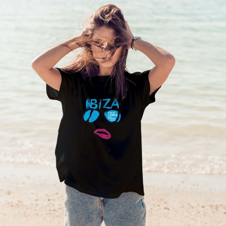 Woman on beach wearing Juxar black Ibiza graphic classic boyfriend t shirt look with relaxed fit and jeans