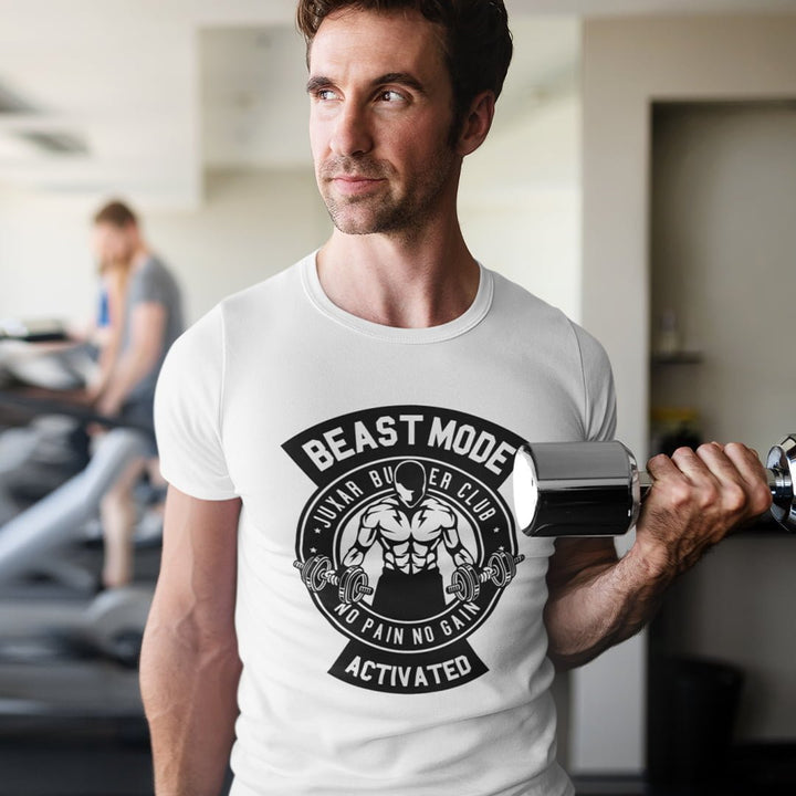 Juxar beast mode t-shirt in white worn by man lifting dumbbell at gym with graphic print