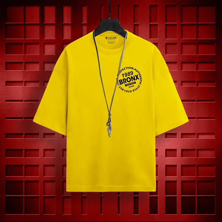 Juxar yellow oversized loose fit t-shirt with Bronx graphic and necklace on hanger