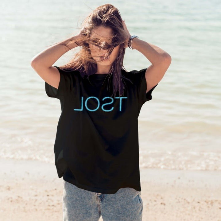 Juxar oversized black boyfriend t shirt outfit ideas with blue neon print styled with light wash jeans on beach