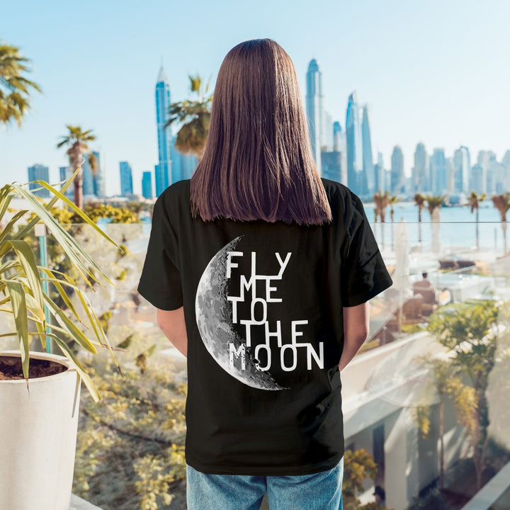 Juxar relaxed boyfriend t shirt for summer black tee with moon back print reading Fly Me To The Moon on model by sunny skyline