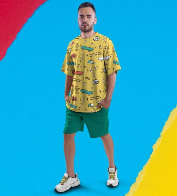 Juxar funky oversized printed t shirt yellow tee with skateboard doodles on male model wearing green shorts