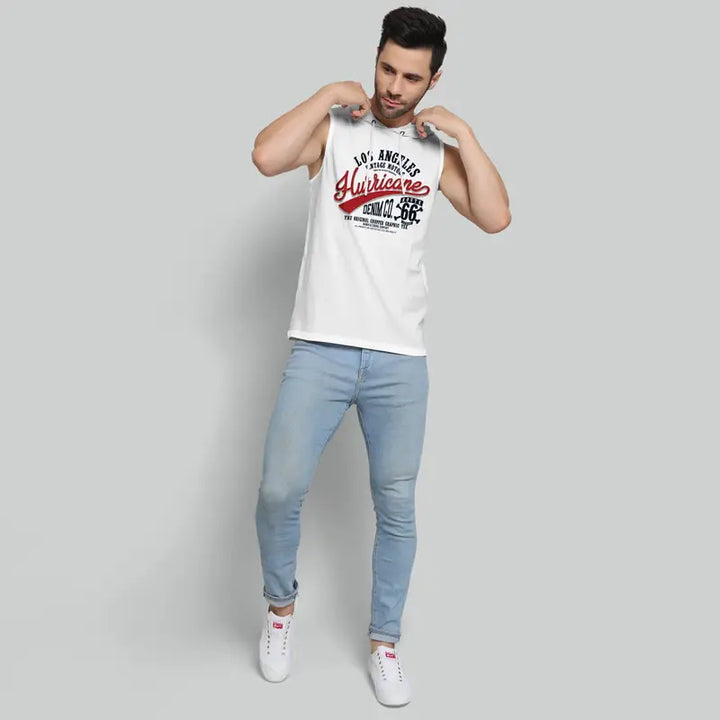 Mens sleeveless white designer gym hoodie with printed text paired with light blue jeans and white sneakers