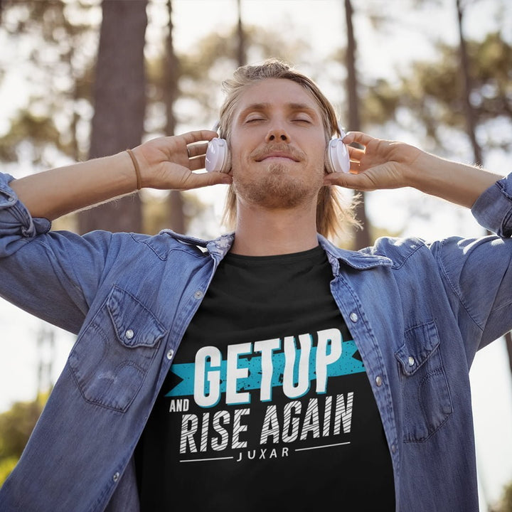 Man wearing Juxar get up rise again t-shirt with denim shirt and headphones outdoors