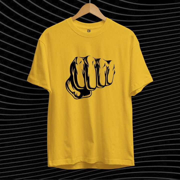 Juxar yellow graphic punch t-shirt with black fist illustration on front hanging on wooden hanger