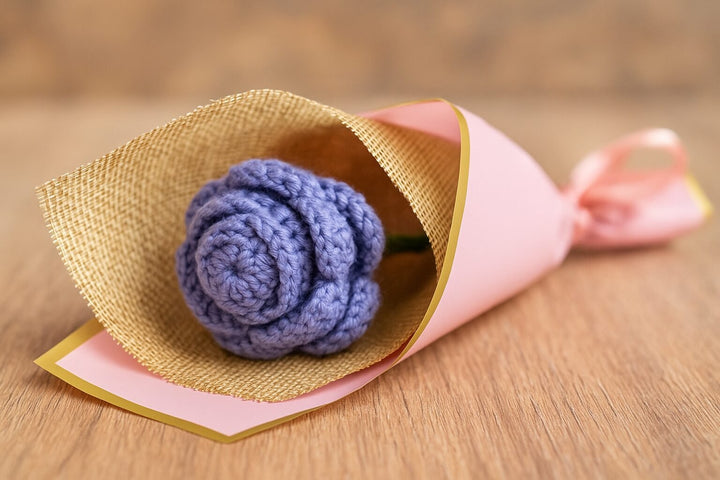 Handmade crochet rose bouquet with a single purple crocheted rose wrapped in burlap and pink paper