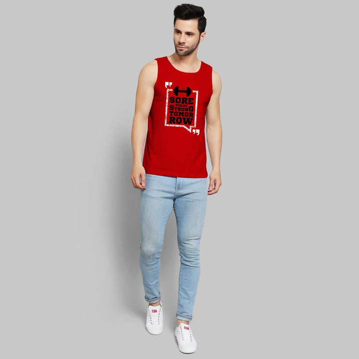 Juxar red gym stringer for men with black motivational print paired with light blue jeans and white sneakers