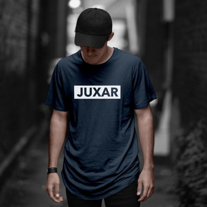 Juxar navy half sleeve cotton longline tee on male model with black cap in moody urban alleyway