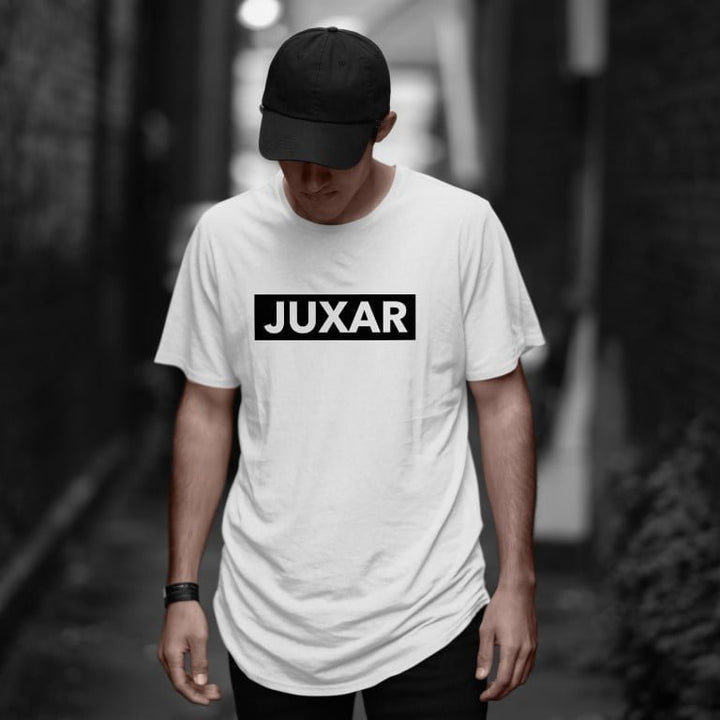 Juxar white half sleeve cotton longline tee with bold black logo worn by model in urban alley
