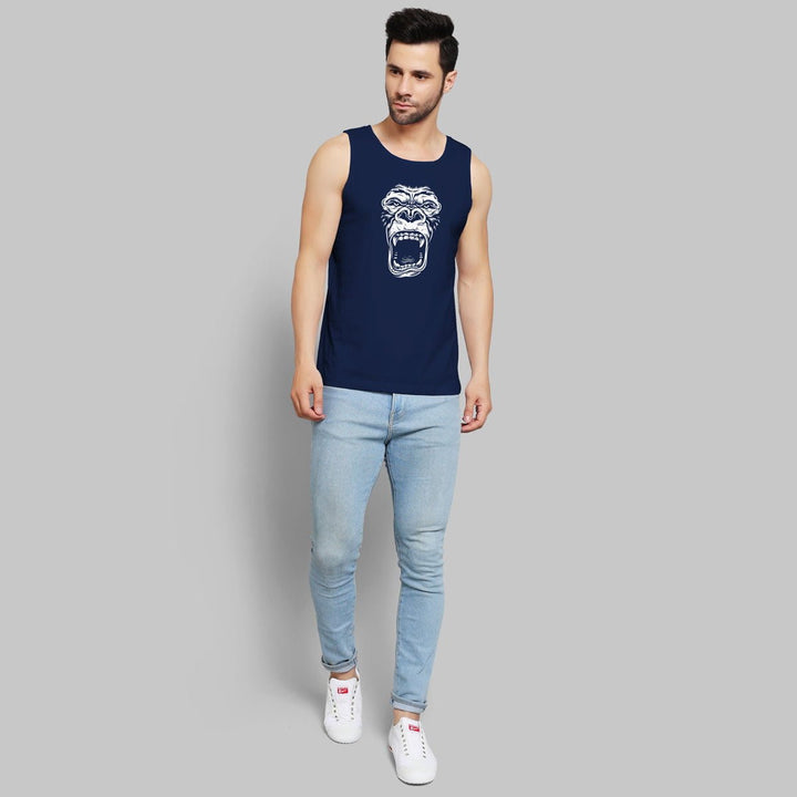 Navy blue muscle tank for men with roaring gorilla graphic worn with light blue jeans and white sneakers