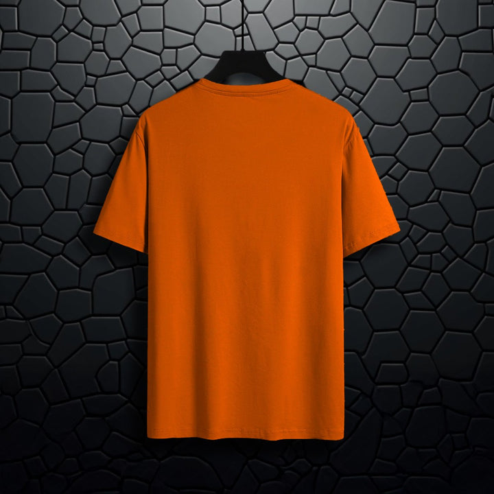 Juxar orange organic cotton t shirt hanging on black textured wall background