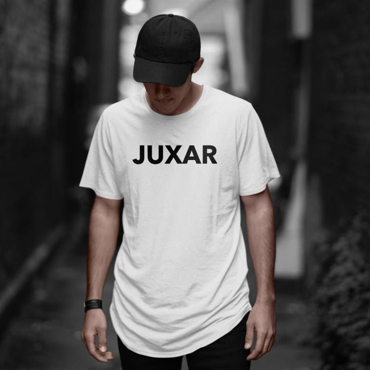 Juxar white premium cotton longline t shirt worn by male model with black cap and wristwatch in urban alley