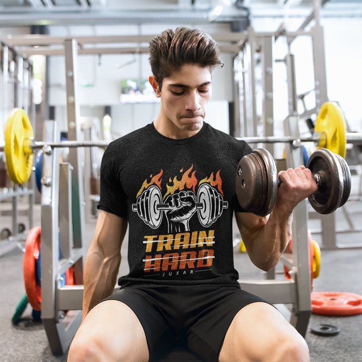 Juxar regular fit cotton t shirt black with Train Hard graphic worn by man lifting dumbbell at gym
