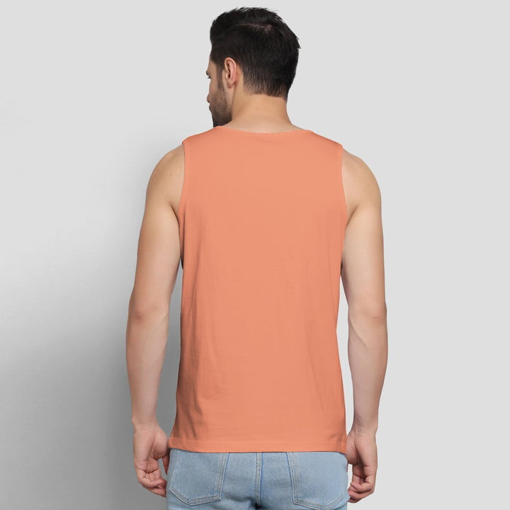 Back view of a man wearing Juxar trendy sando for men in peach color with light blue jeans