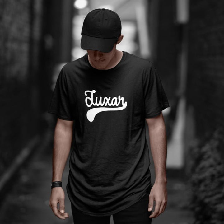Juxar black luxury cotton longline t shirt with white script logo on male model in urban alley