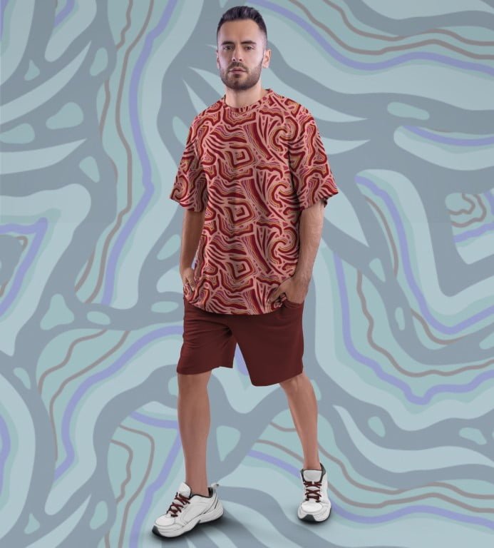 Juxar vintage oversized printed t shirt red abstract swirls on male model paired with maroon shorts and white sneakers