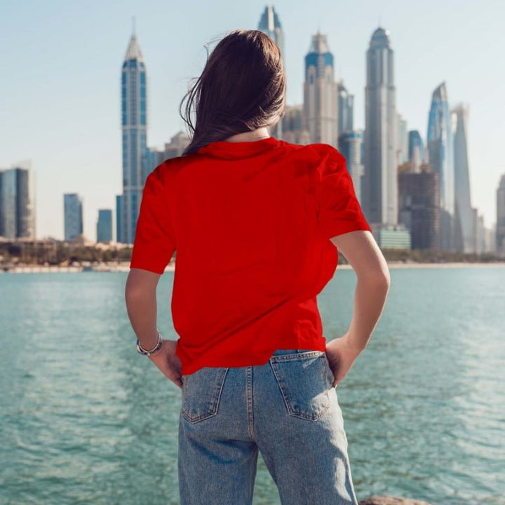 Juxar minimal boyfriend t shirt in red back view on model with relaxed fit paired with jeans by waterfront skyline