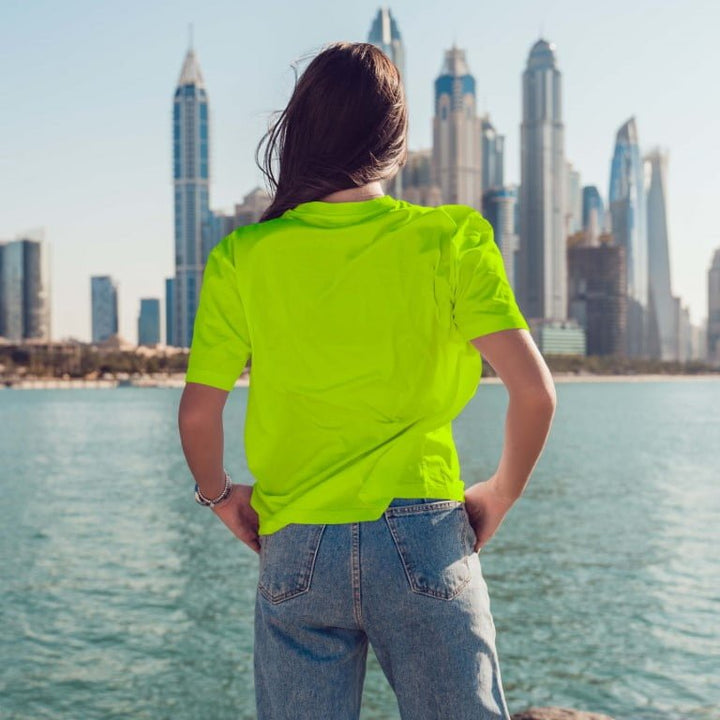 Juxar neon green happiness boyfriend t-shirt relaxed fit back view on model by waterfront city skyline casual wear