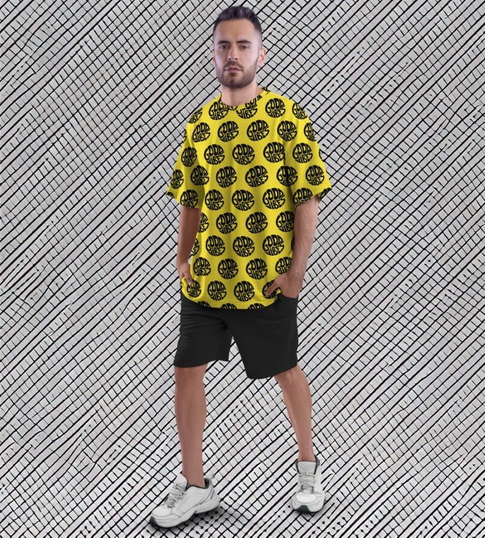 Juxar street style oversized printed t shirt yellow with black circular print on male model wearing shorts and sneakers