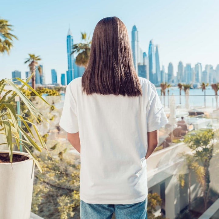 Juxar white soft boyfriend t shirt cotton on model back view overlooking city skyline with palm trees